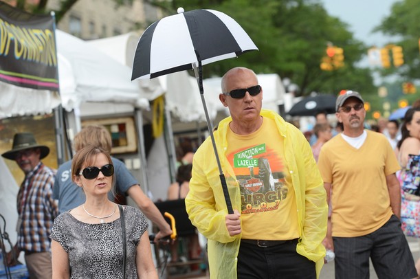 Cindy Miller walks with her husband Phil, both of Arizona, as he carries a tiny golf umbrella while it sprinkles on Main St during the Summer Art Fair on Wednesday. Melanie Maxwell I AnnArbor.com